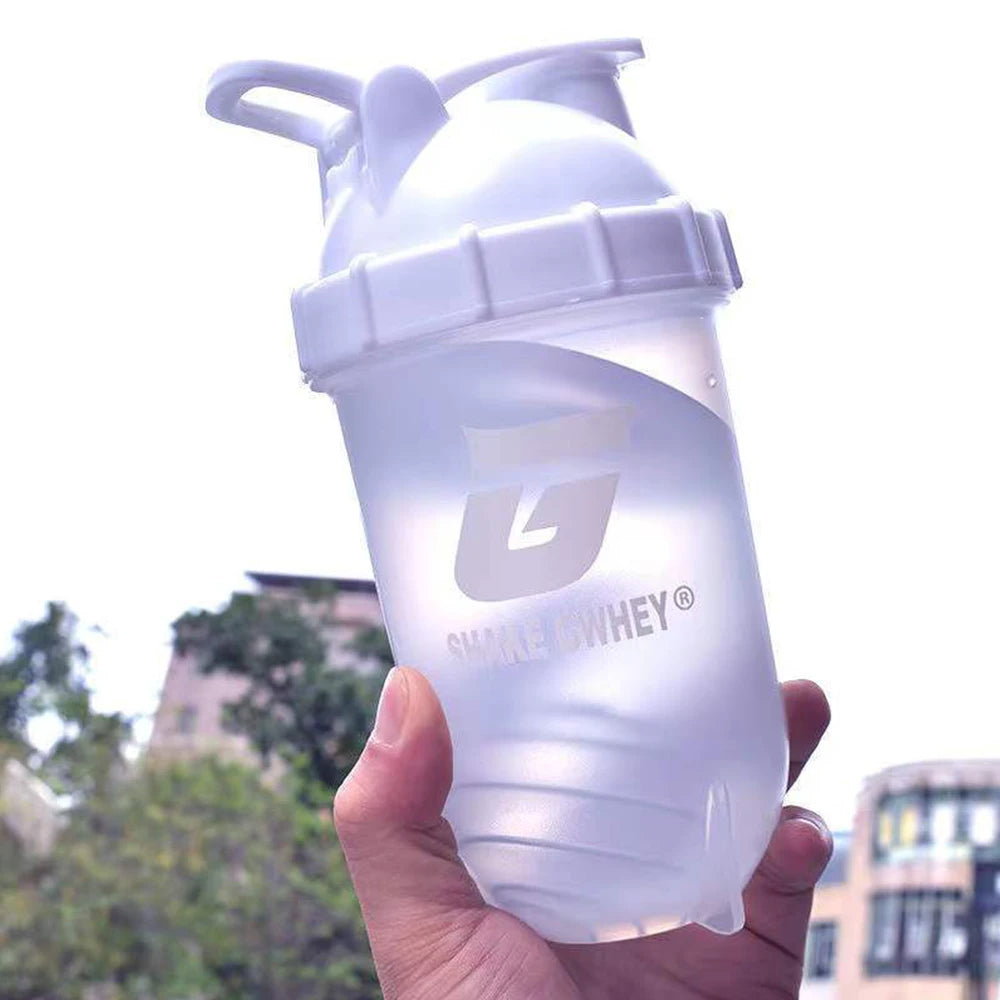 Gourde shaker protéinée 500 ml pour le sport, idéale pour mélanger la poudre de protéines et pour la salle de sport. Bouteille en plastique avec gobelet mélangeur.