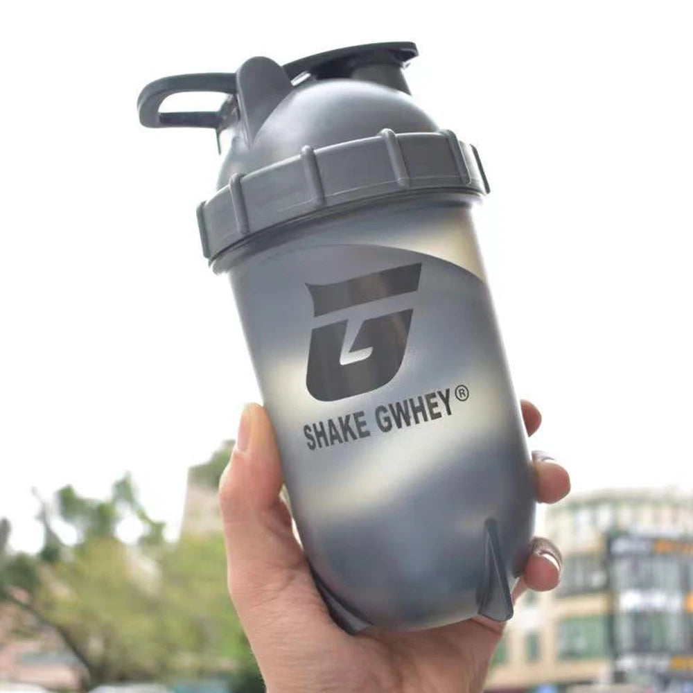 Gourde shaker protéinée 500 ml pour le sport, idéale pour mélanger la poudre de protéines et pour la salle de sport. Bouteille en plastique avec gobelet mélangeur.