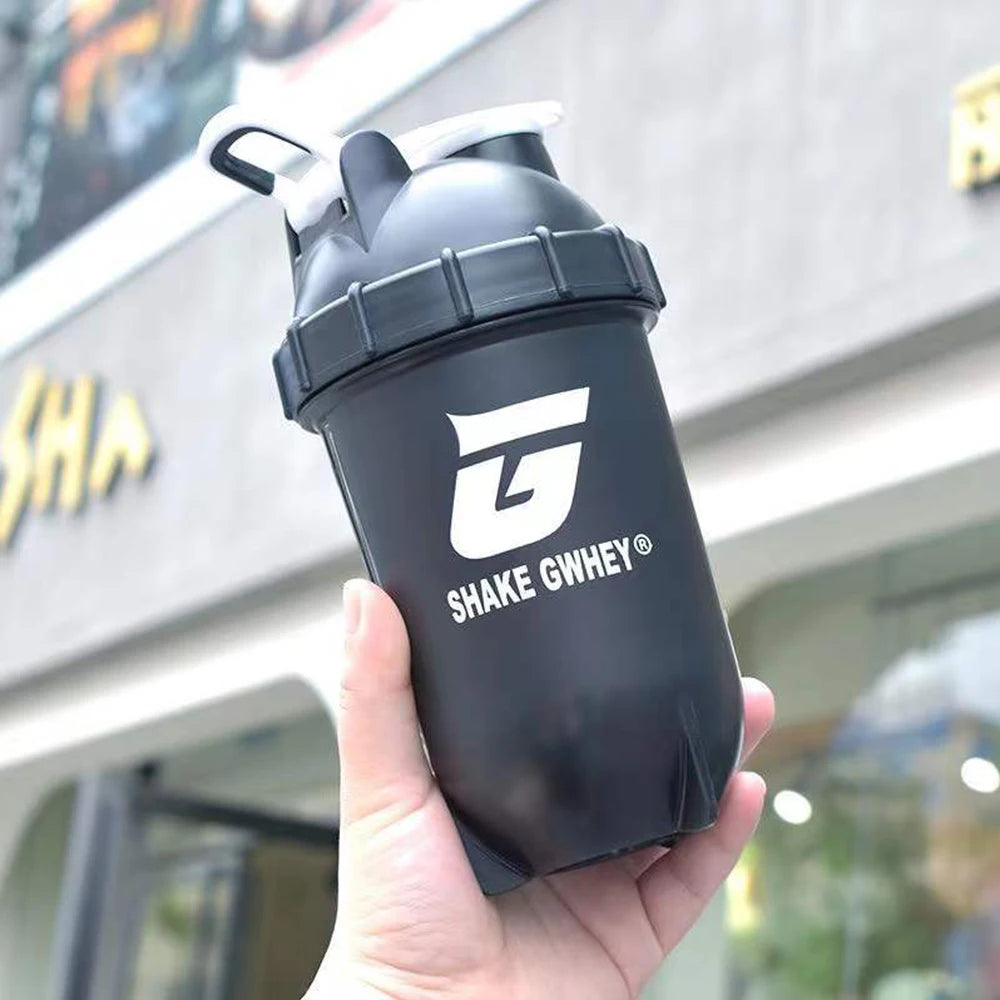 Gourde shaker protéinée 500 ml pour le sport, idéale pour mélanger la poudre de protéines et pour la salle de sport. Bouteille en plastique avec gobelet mélangeur.